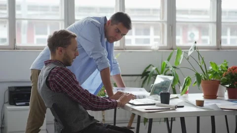 Two web designers discussing ideas at desk Stock Footage 142509221