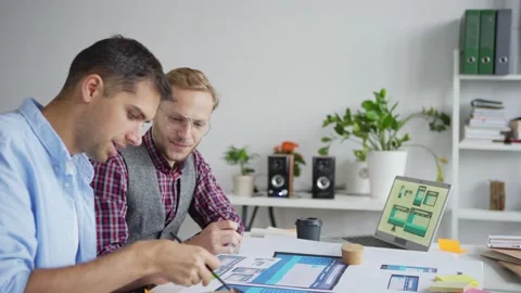 Two web designers sharing ideas in office Stock Footage 142520356
