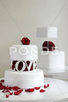 Two Wedding Cakes With Decorated With Red Roses