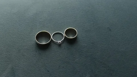 Two wedding gold rings and a diamond engagement ring in the middle lie on a 库存影片 306145221