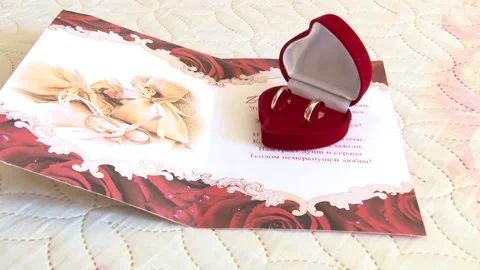 Two wedding golden rings on the postcard Stock Footage