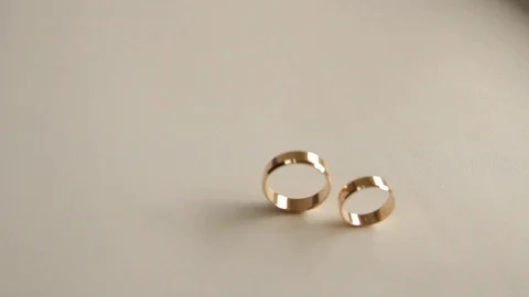 Two wedding rings are lying on the table, the camera is hitting Stock Footage 101818501