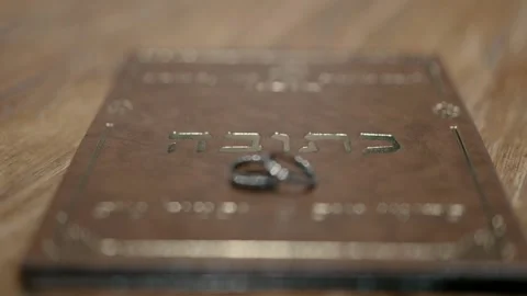 Two wedding rings are placed on the ketubah on the wedding day. Stock-Footage 221574757