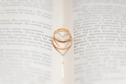 Two wedding rings on a book page. Stock Photos