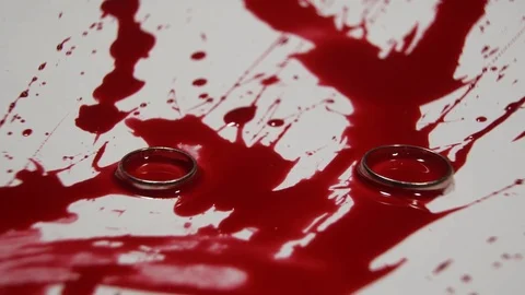 Two wedding rings fall in blood. Stock Footage 82900469
