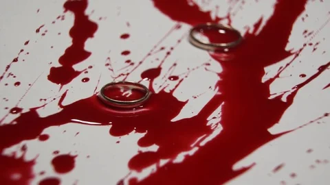 Two wedding rings fall in blood. Stock Footage 82900502