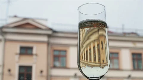 Two wedding rings fall in a glass of bubbling champagne Stock Footage 62803423