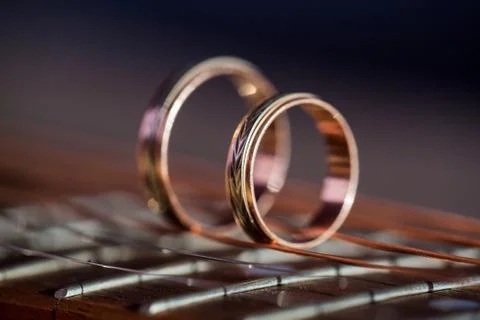 Two Wedding Rings on guitar strings. Shallow Depth Of Field Stock Photos