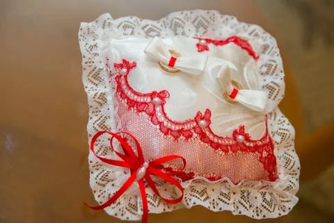 Two wedding rings lie on a rectangular pillow lace. Stock Photos