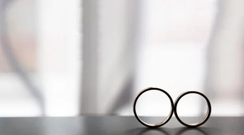 Two wedding rings next to the window Stock Photos