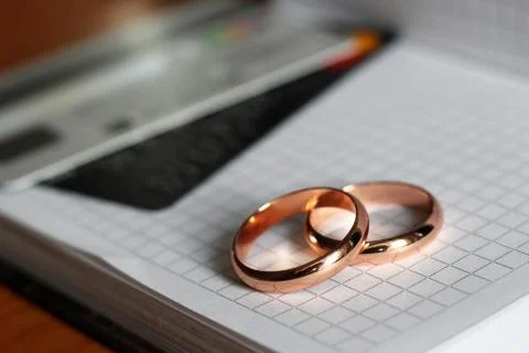 Two Wedding Rings resting on a paper page Stock Photos