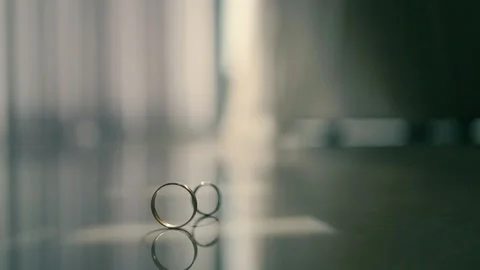 Two wedding rings spins on the table. Stock Footage 225639423