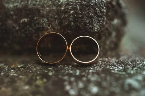 Two wedding rings on a stone Stock Photos