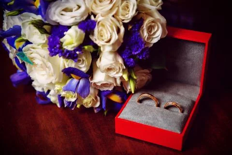 Two wedding rings with white flower in the background in the red box Stock Photos