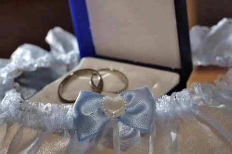 Two weeding rings in box with blue garter around Stock-Fotos