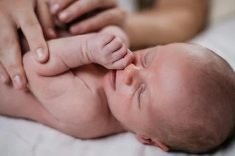 Two week old very cute baby naked on a white sheet Stock Photos