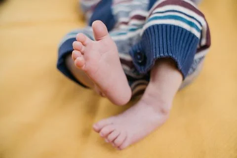 Two week old very cute baby in overalls on an orange plaid Stock Photos