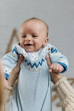 Two week old very cute baby in overalls on an orange plaid Foto stock