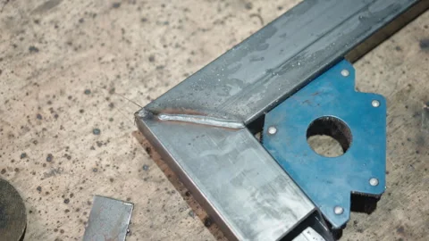 Two welded under the angle metal planks on working table surface in workshop Stockbeeldmateriaal 264768749