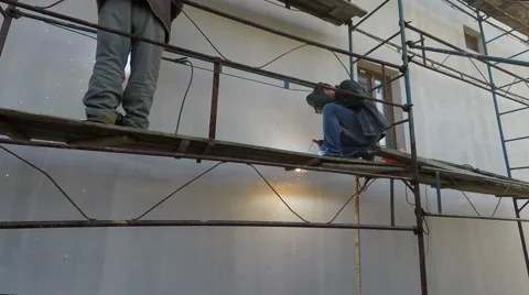 Two welders working on the scaffolding. Lots of sparks. Stock Footage 61144651