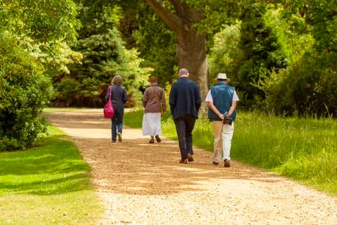 Two well dressed elderly men and two elderly women are having a leisurely stroll Stock Photos