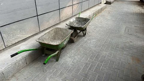 Two Wheelbarrows Facing Each Other on Pavement Stock Photos