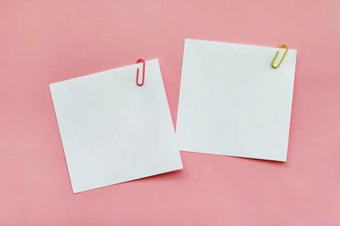 Two white blank note papers with clips on light pink background Stock Photos
