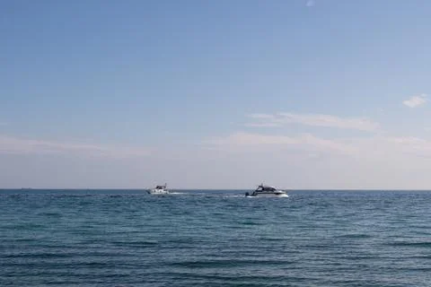 Two white boats navigating in different directions in the sea on a summer day Stock Photos