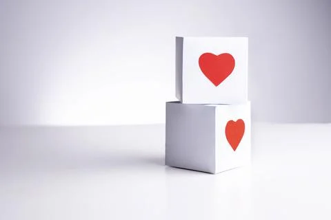 Two white boxes with red hearts on top of each other on a white background, c Foto stock