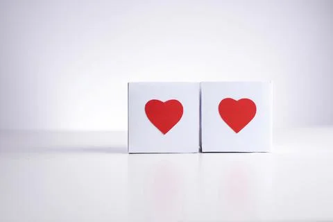 Two white boxes with red hearts  on a white background, close up, copy space. Foto stock