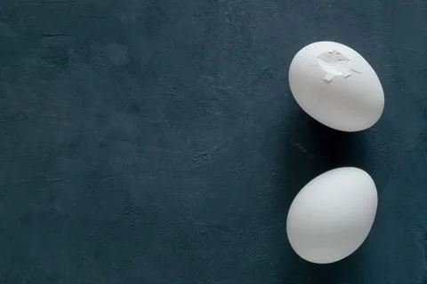 Two white broken chicken eggs on a black background Stock Photos