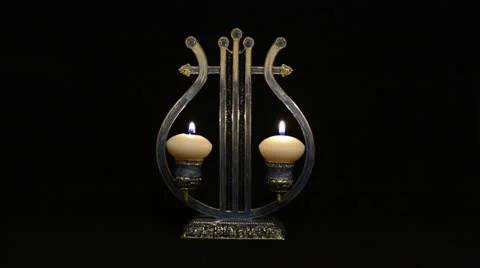 Two white candles in a candlestick form of lyre Stock Footage 21325326