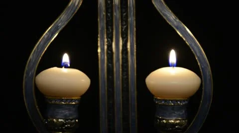 Two white candles in a candlestick form of lyre on black background Stock Footage 21325429