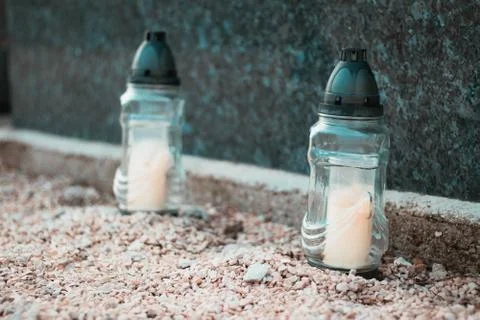 Two white candles in front of a marble grave , public cemetary. Stock Photos