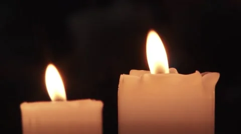 Two white candles, thick burning. The first candle is melted by the flame Stock Footage 59648588