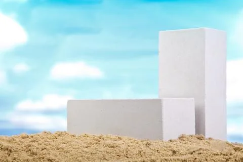 Two white ceramic bricks on the sand at the blue sky background Stock Photos