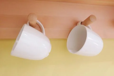 Two White Ceramic Coffee Cup Hanging on The Wall Stock Photos