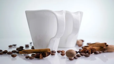 Two white ceramic cup with coffee beans rotating on a white background. Stock Footage 129593327