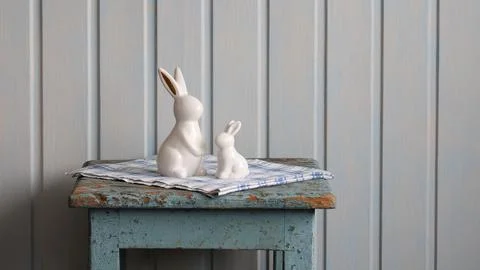 Two white ceramic easter bunnies sitting on rustic table Stock Photos