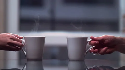 Two white ceramic mugs on the table a man and a woman take them and put them Stock Footage 132647273