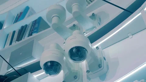 Two white circular security cameras and a fire alarm sensor on a mirror ceiling Stock Footage 323911983