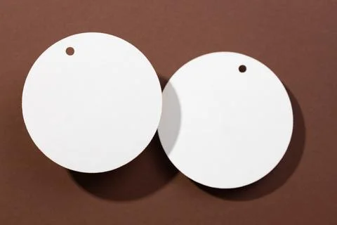 Two white colored cardboard blank tags of circle shape and same size with little Stock Photos
