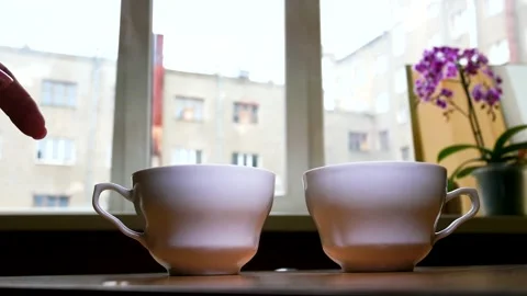 Two white cups on the background of the window. Breakfast for two Stock Footage 153103802