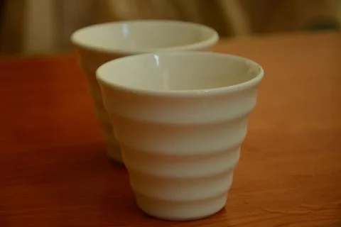 Two white cups on the brown table Stock Photos