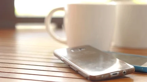 Two white cups of coffee are on the table in the cafe, next to it there are two Stock Footage 90420129