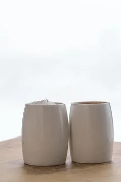 Two white cups of coffee stand on a world map against a light background Stock Photos