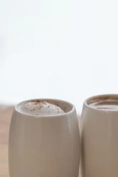 Two white cups of coffee stand on a world map against a light background Foto stock