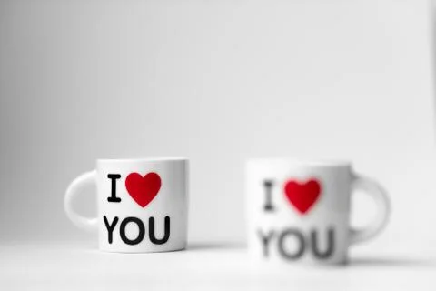 Two white cups with a red heart and an inscription I love you on a white Stock Photos