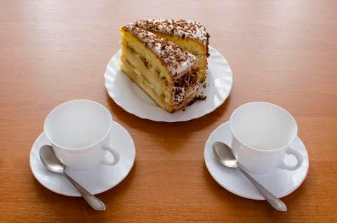 Two white cups of tea and cake. Stock Photos