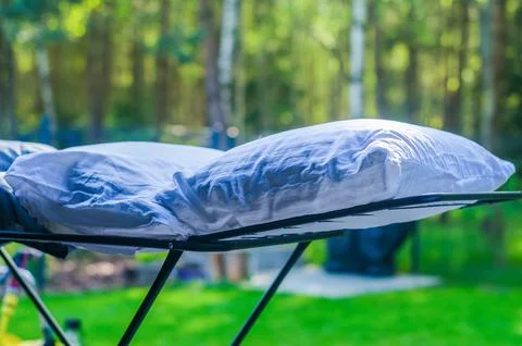 Two white down pillows are dried or ventilated in an open air in the garden Stock Photos